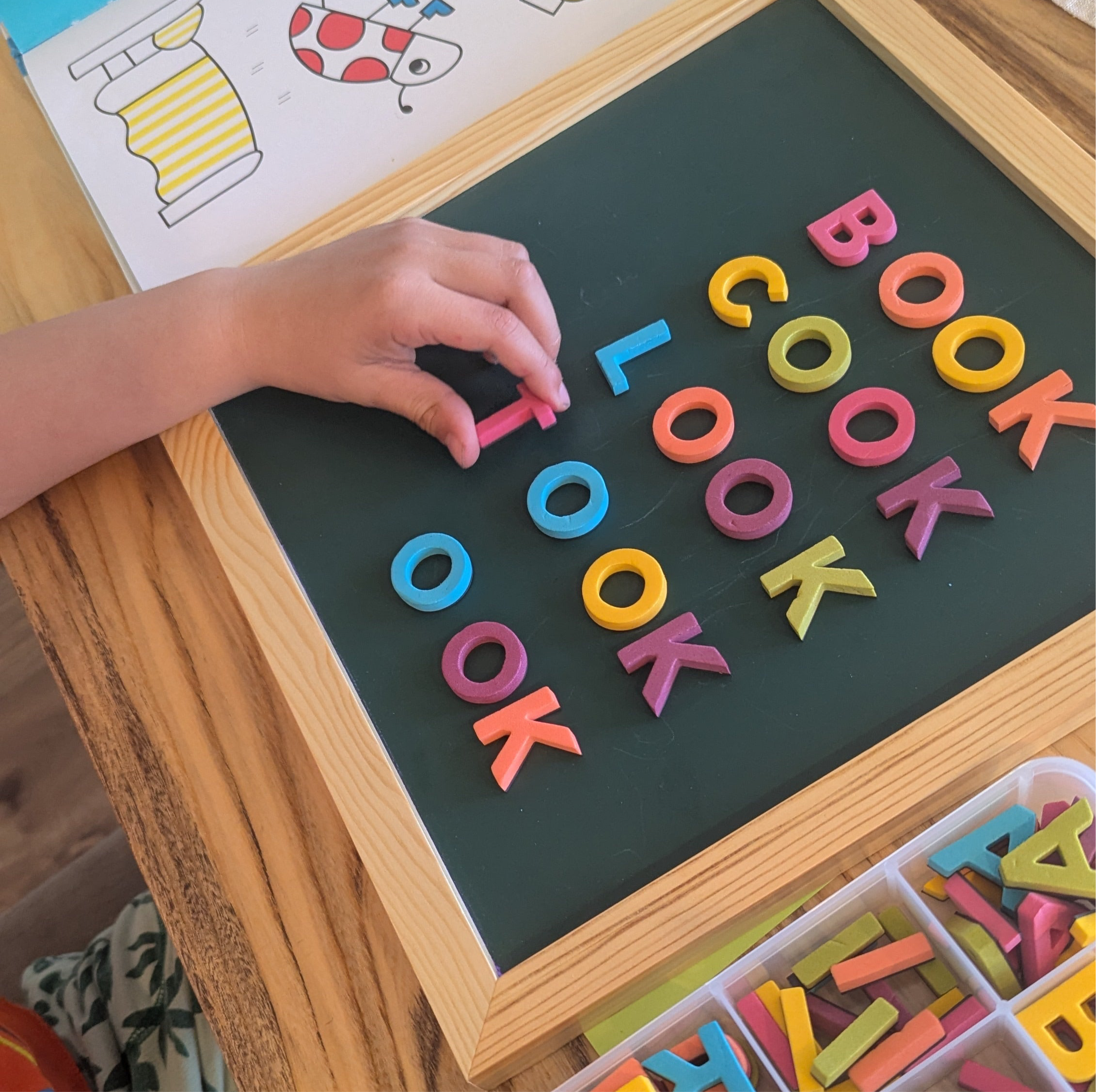 Child practicing sight words with rainbow magnetic letters of green magnetic letter board