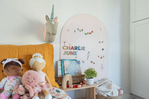 Girls bedroom with pink arch-shaped magnetic wall decal and rainbow magnetic letters
