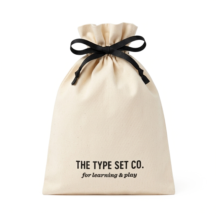 Natural colored canvas drawstring bag with blag ribbon tied in a bow.