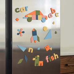 Colorful magnetic letters and shapes on a refrigerator door