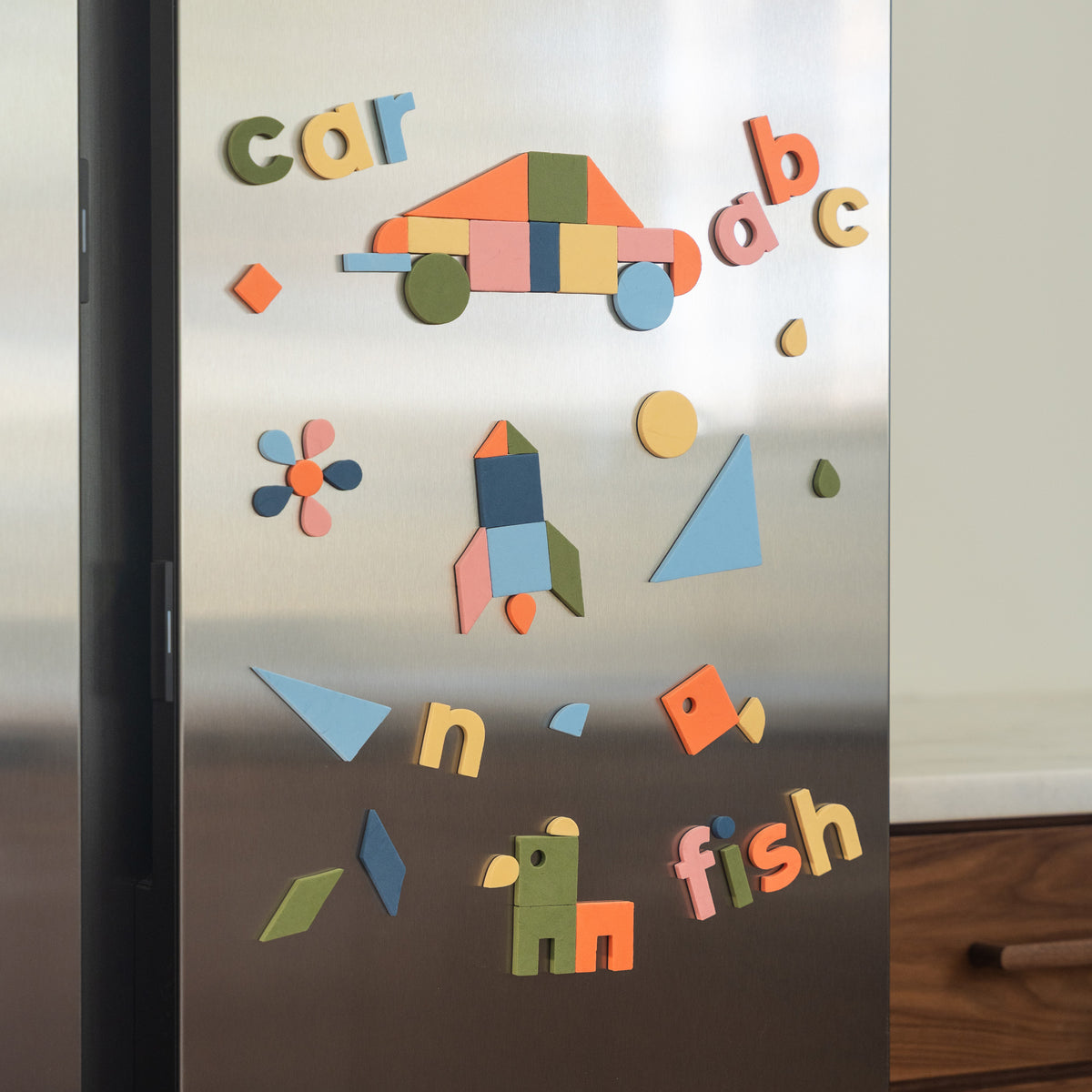 Colorful magnetic letters and shapes on a refrigerator door