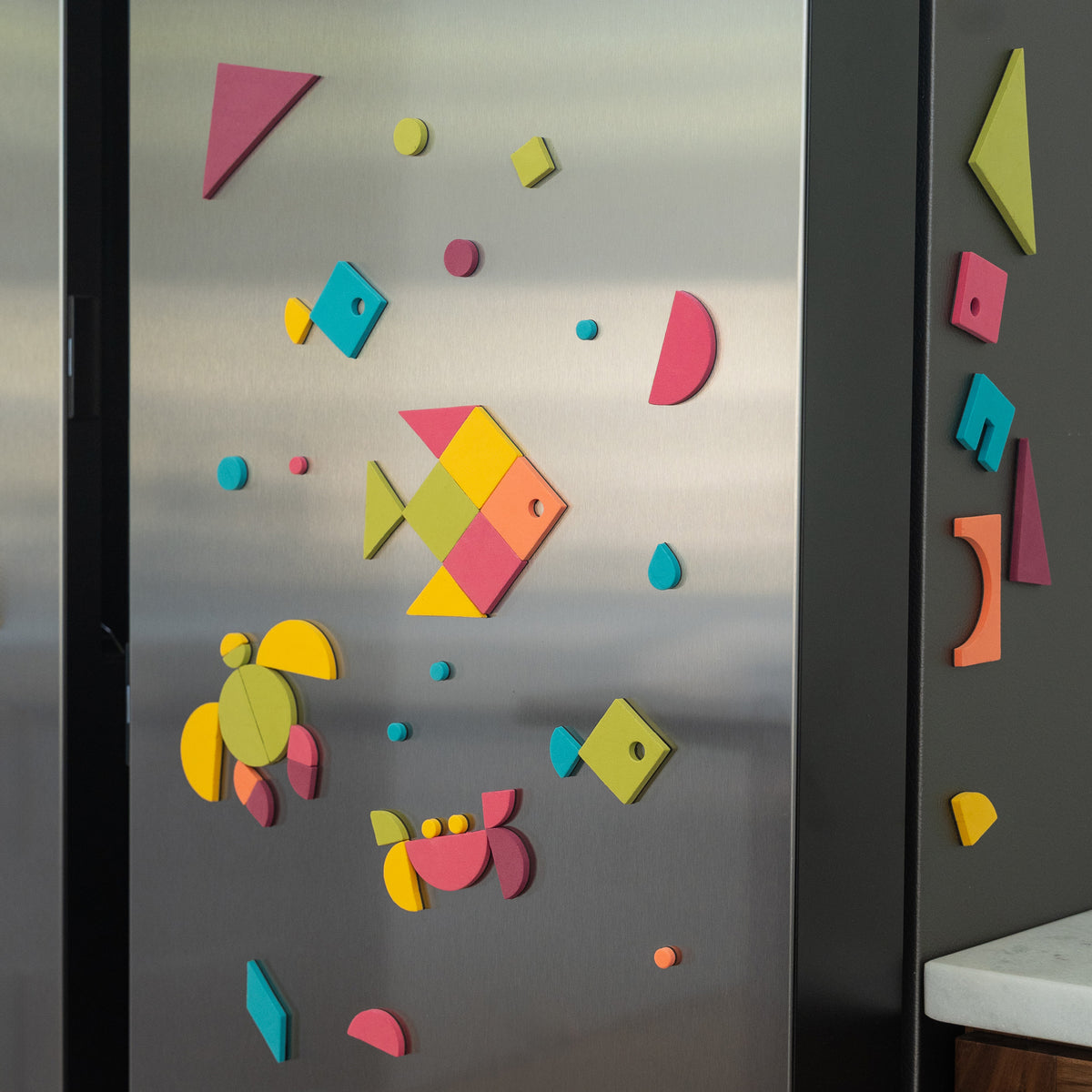 Colorful geometric magnetic shapes on a stainless fridge