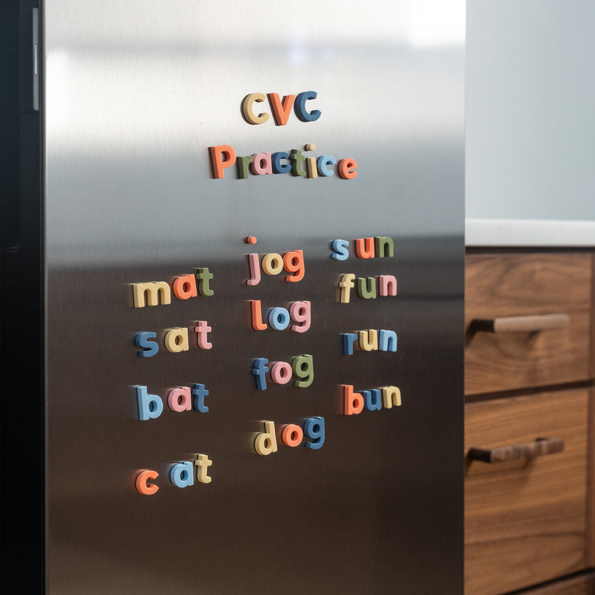 Colorful CVC practice word letter magnets on a refrigerator door