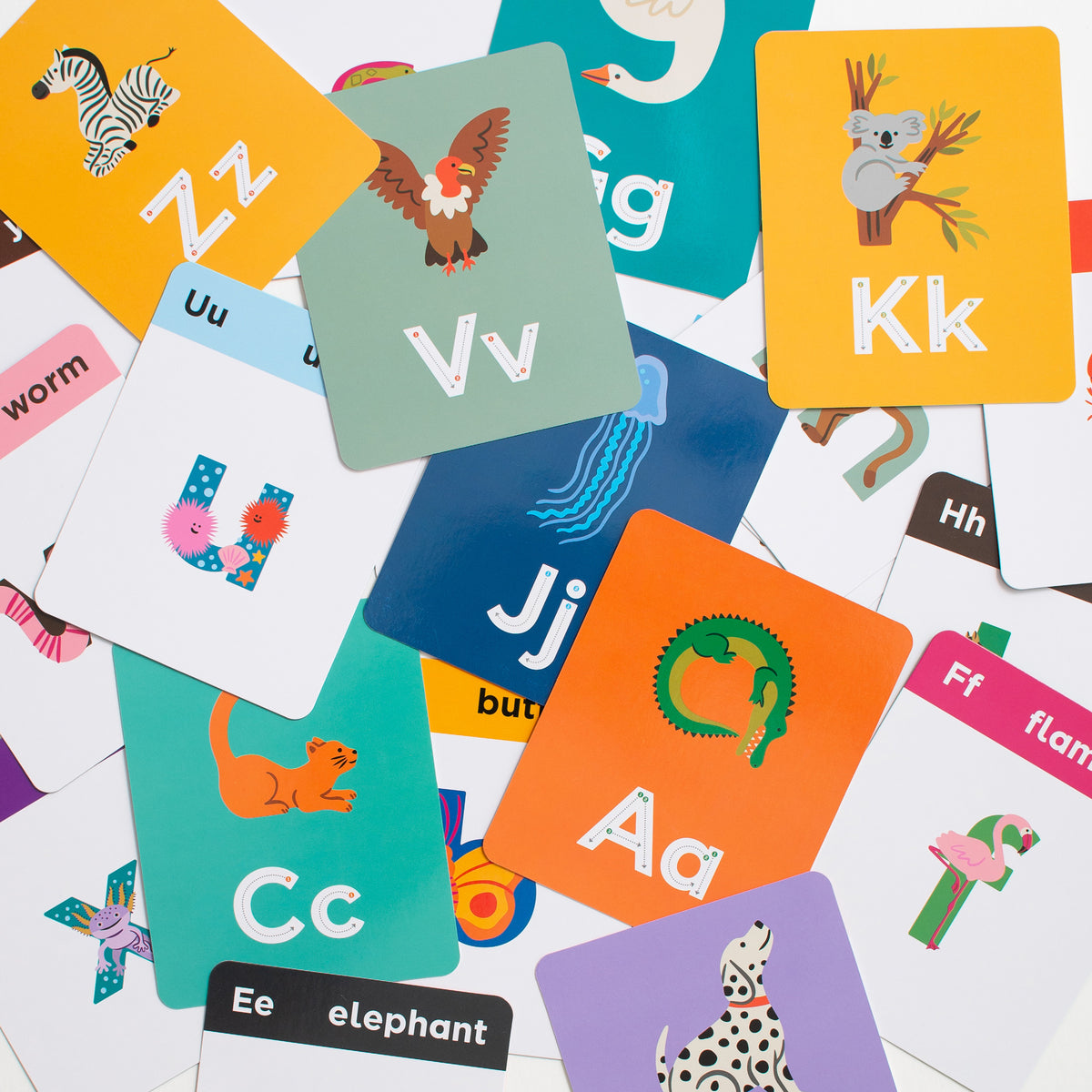 Scattered animal alphabet flashcards featuring animals shaped like lowercase letters and traceable upper and lowercase letterforms.
