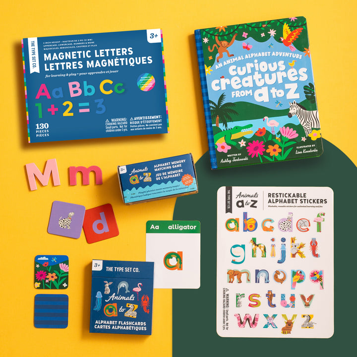Animals A to Z Complete Educational Alphabet Bundle featuring, magnetic letters, alphabet storybook, memory matching game, alphabet flashcards, nano stickers, and mini magnetic wall decal on yellow background.