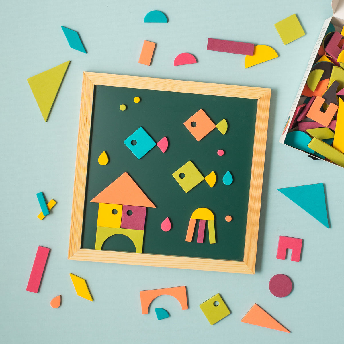 Geometric shape magnets making underwater scene on green chalkboard on blue background