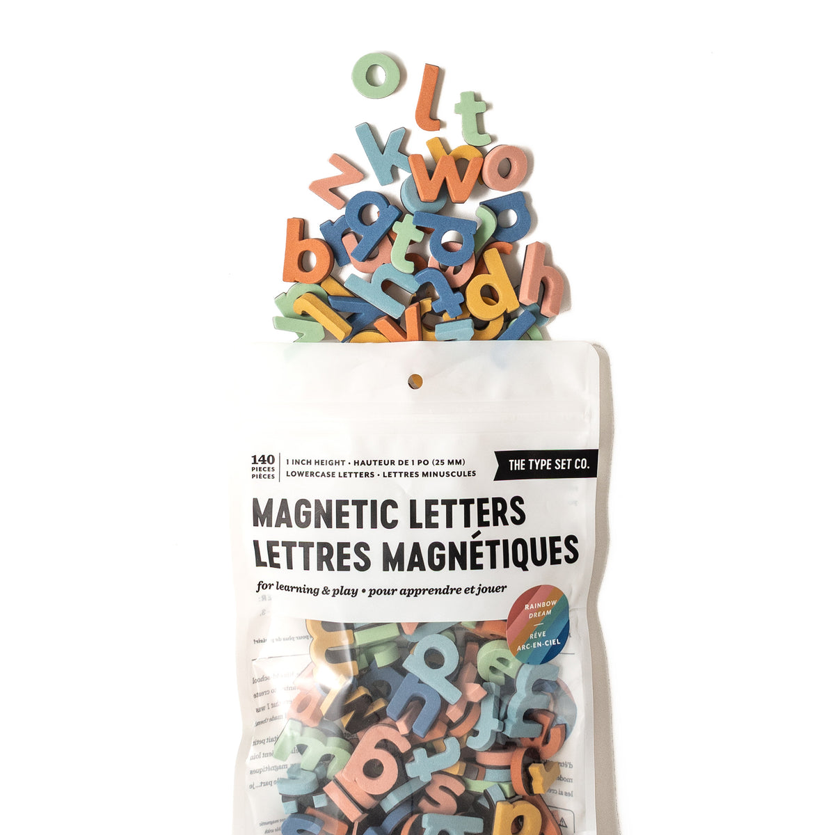 Rainbow dream magnetic lowercase letters spilling out of packaging on white background
