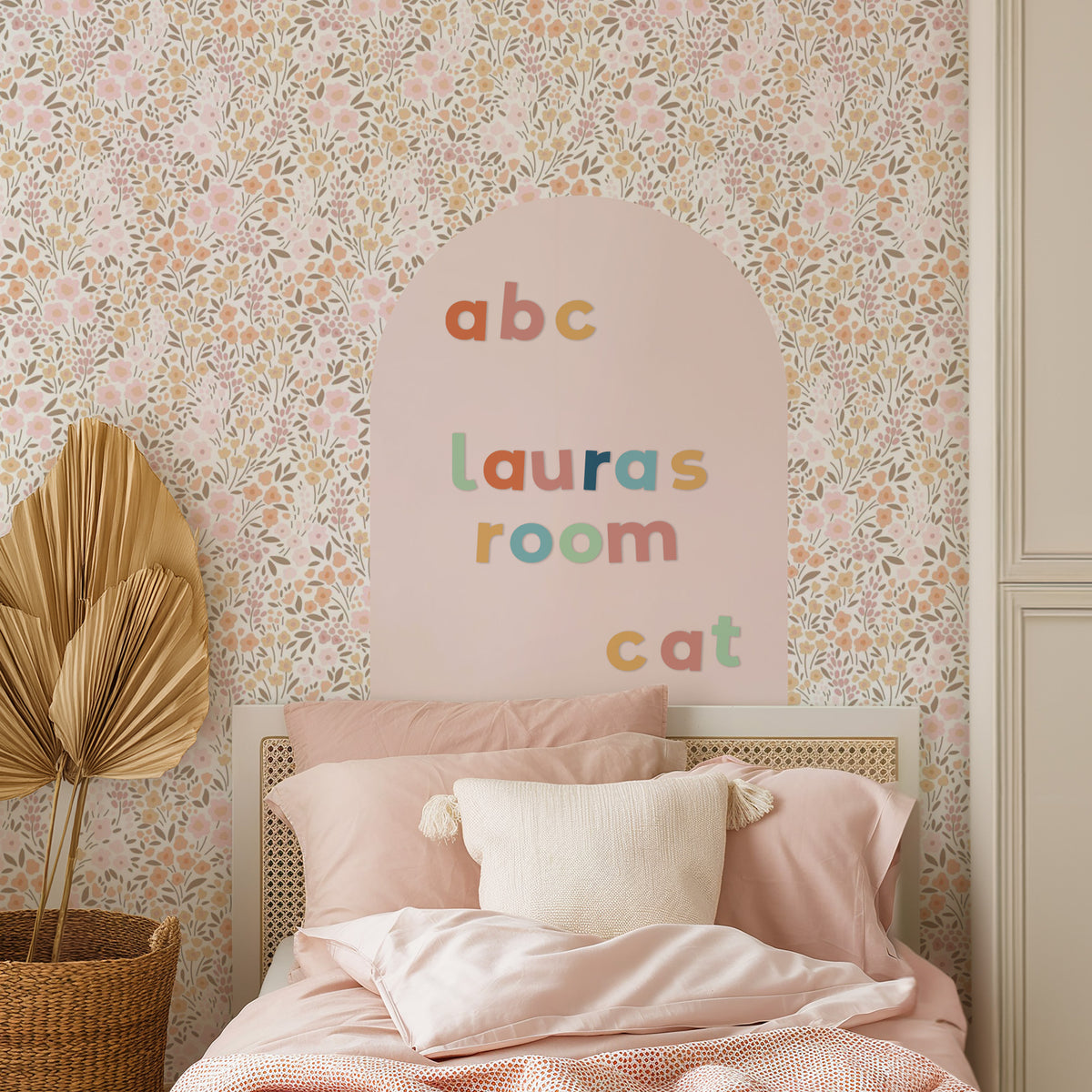 Children's bedroom with pink magnetic wall decal and rainbow dream lowercase letters spelling 'lauras room' and 'cat'