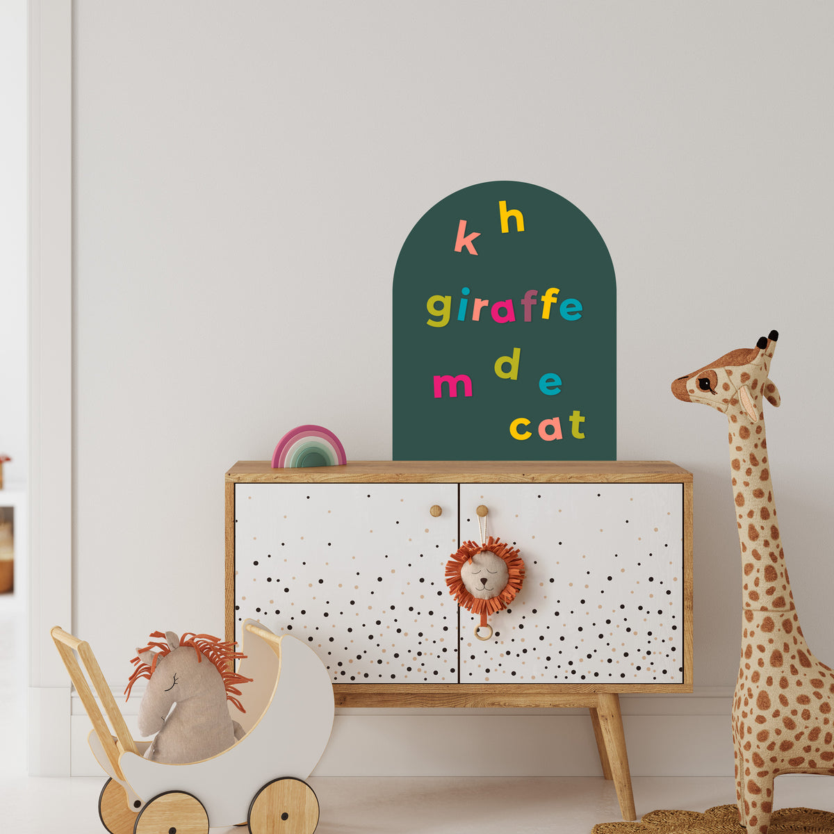 Children's room with a cabinet, toys, and a green mini magnetic wall decal featuring colorful alphabet magnets.