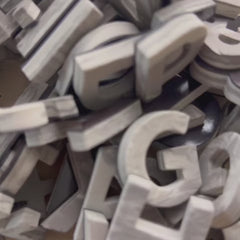 Close-up video of Driftwood Gray faux wood foam magnetic letters being squeezed to show their soft, flexible texture