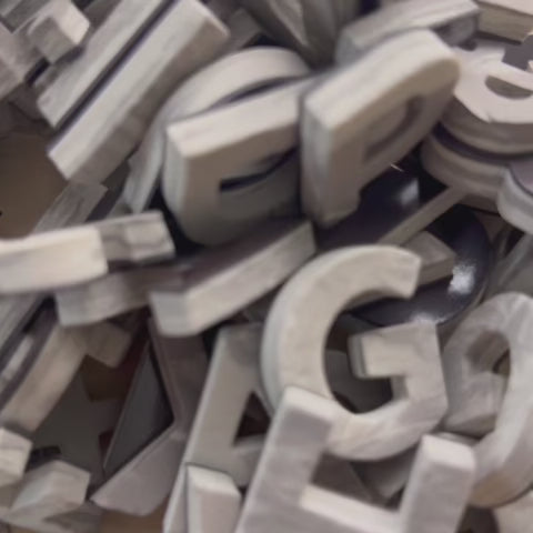Close-up video of Driftwood Gray faux wood foam magnetic letters being squeezed to show their soft, flexible texture