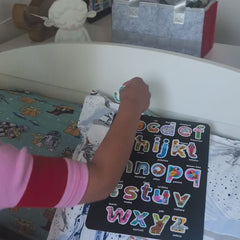 Video of a boy peeling lowercase animal alphabet stickers off the sheet and spelling his name, Gabriel, on his headboard.
